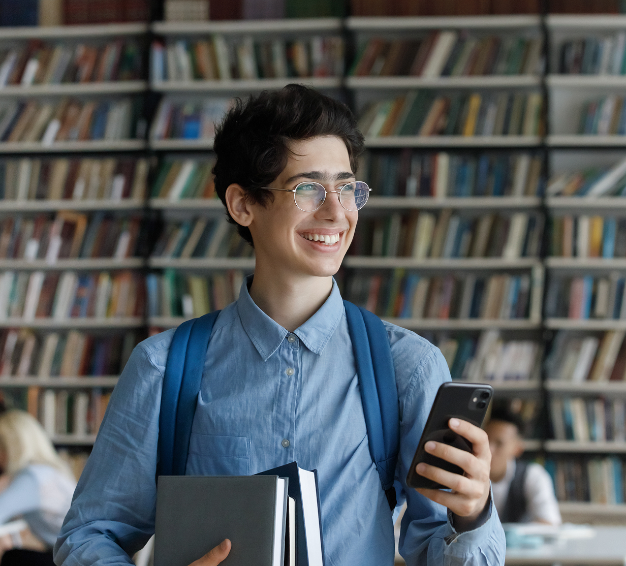 Student in library with books and phone